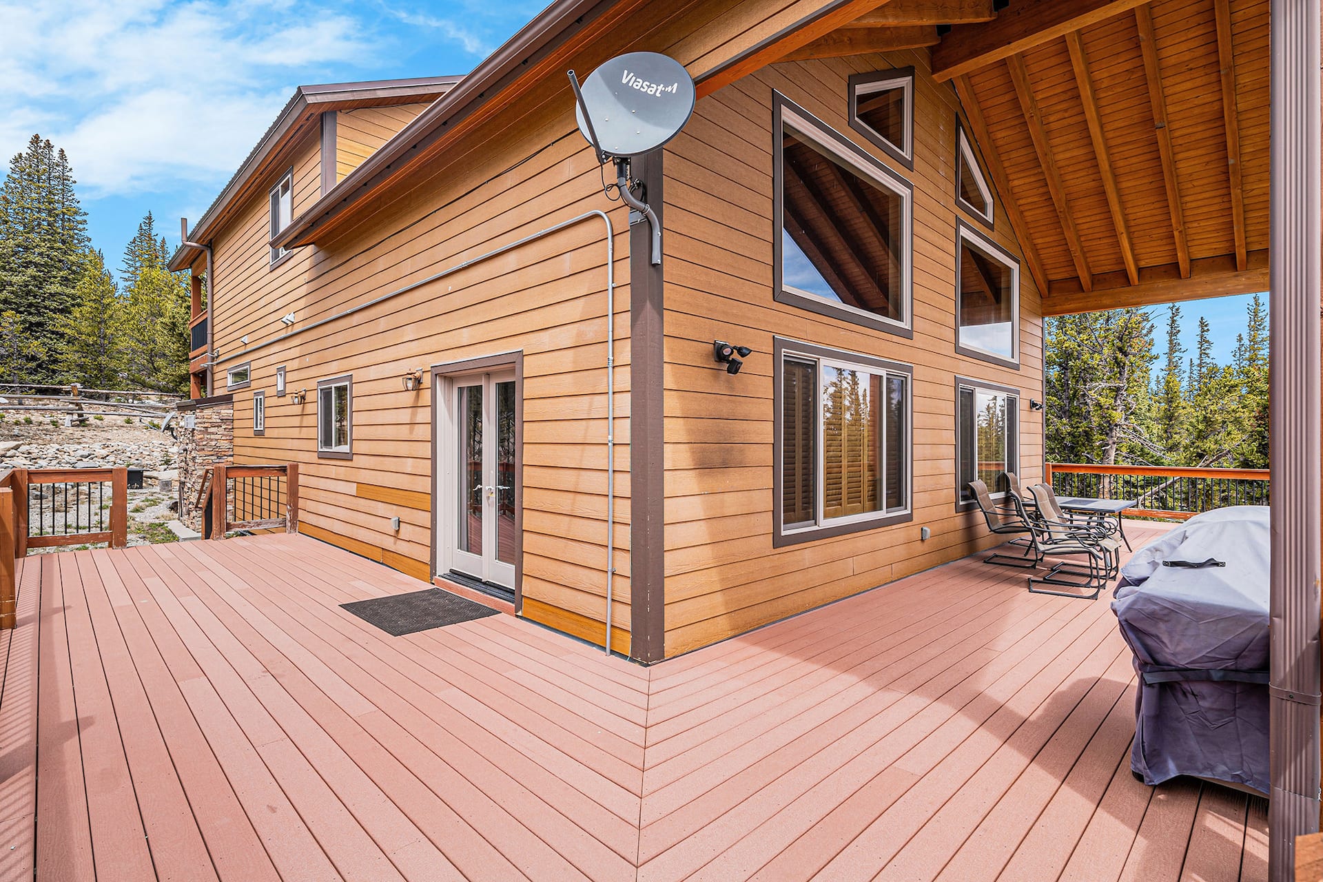 Wide view of the wraparound deck with a grill and seating